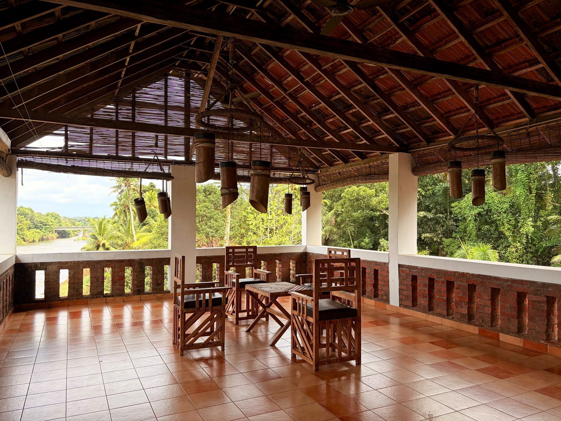 The rooftop seating area at De Charlie's Pamba Heritage, with hanging bamboo lanterns and a view over the Pamba