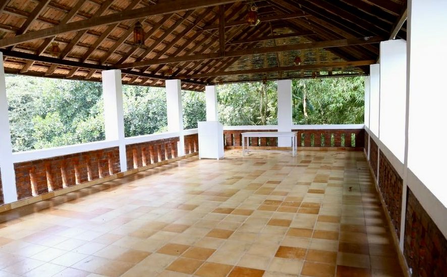 Covered rooftop pavilion with wood beam ceiling, overlooking the trees